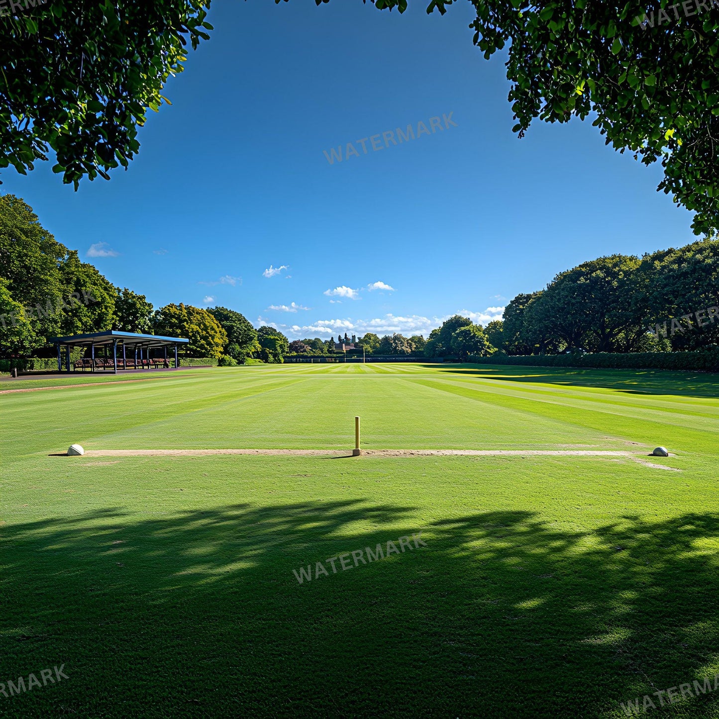 a large green field with trees in the background