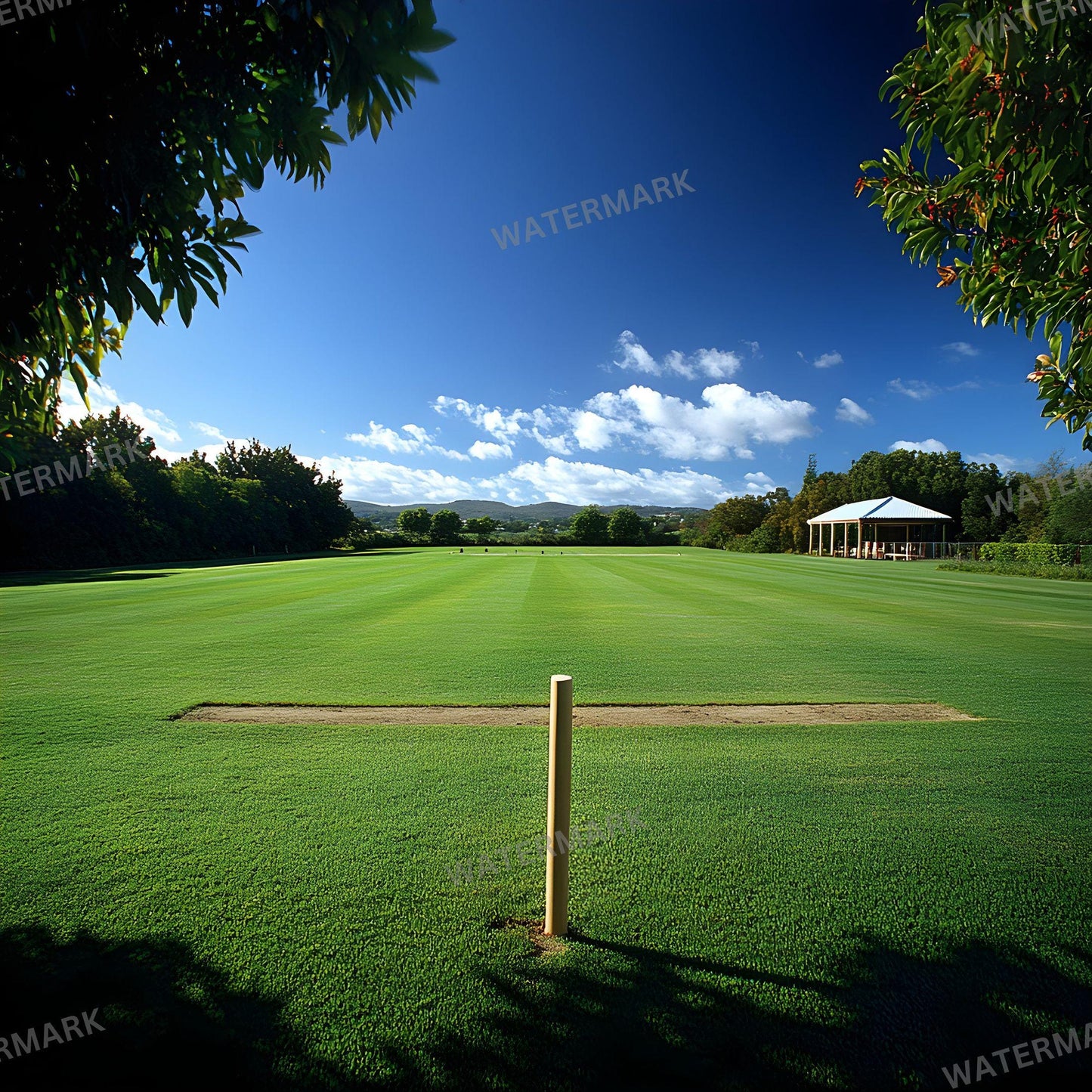 a green field with a white tent in the distance